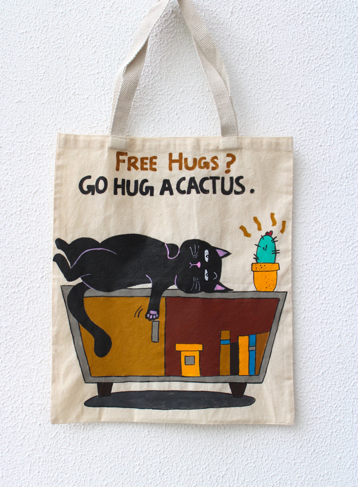 Funny cat tote bag with sarcastic "Go Hug a Cactus" quote and unique painted design.