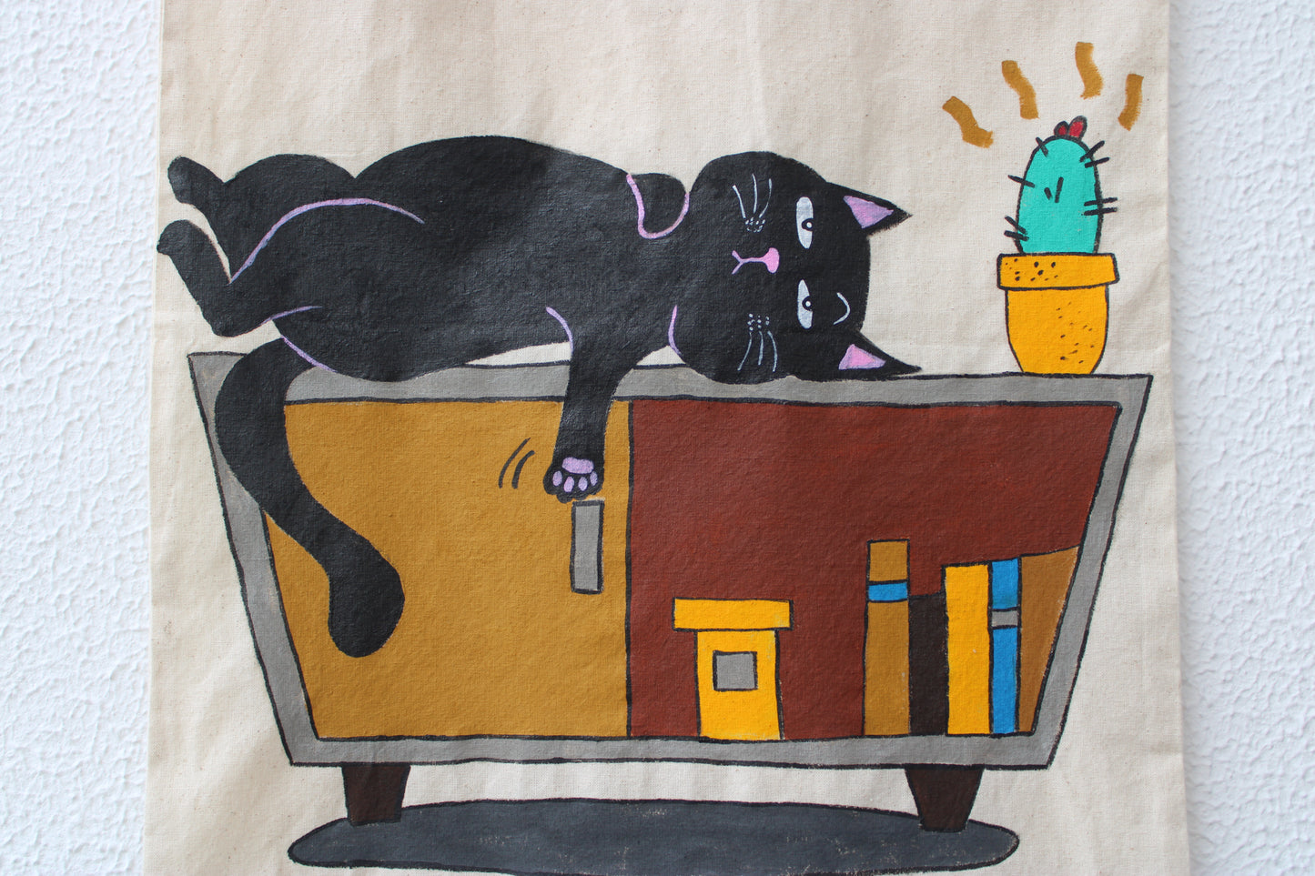 Close-up of the detailed hand-painted black cat and cactus art on a unique cloth tote bag.
