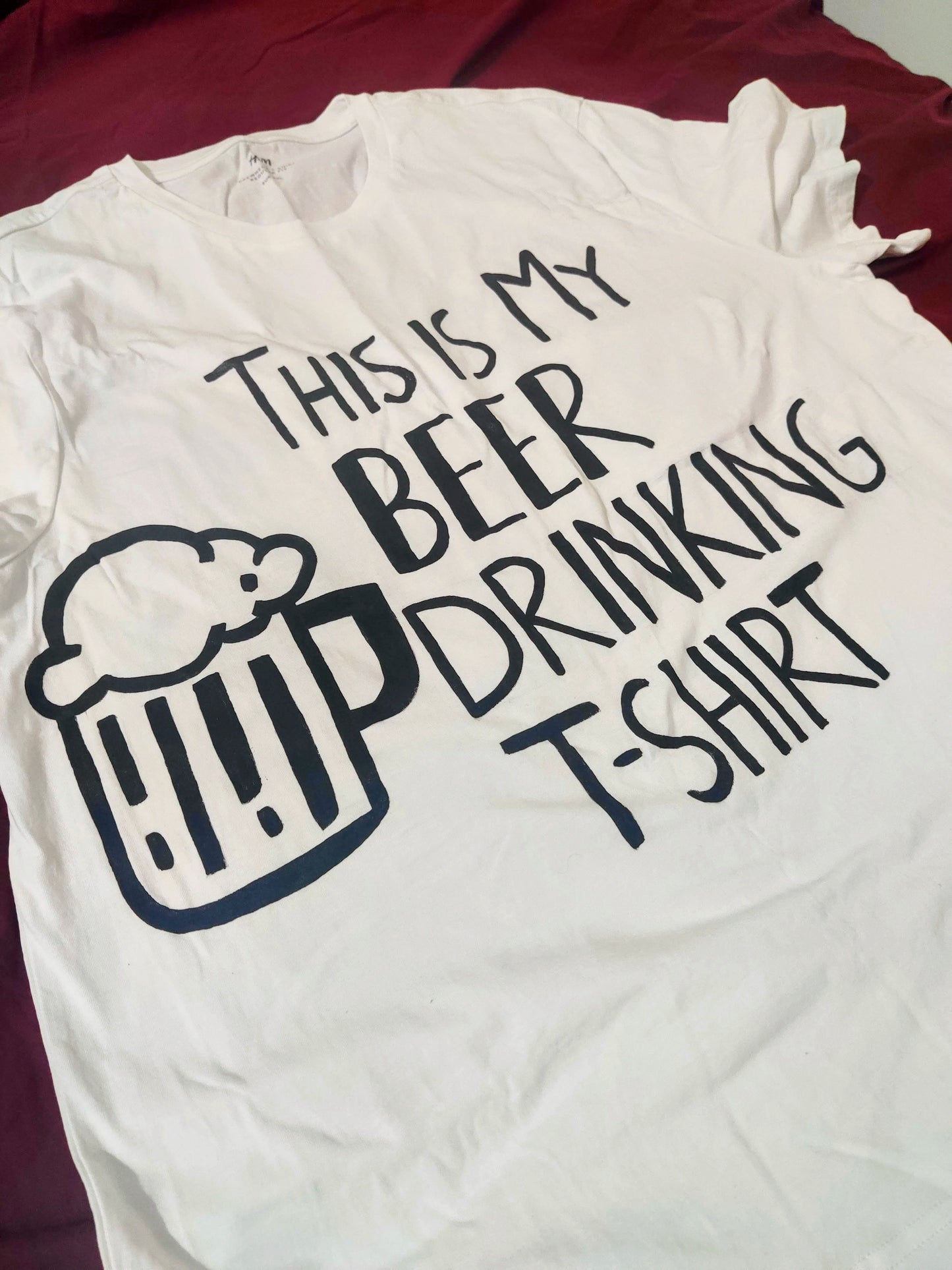 Close-up of the hand-painted text and beer mug design on a funny beer t shirt, showing the unique artwork details.