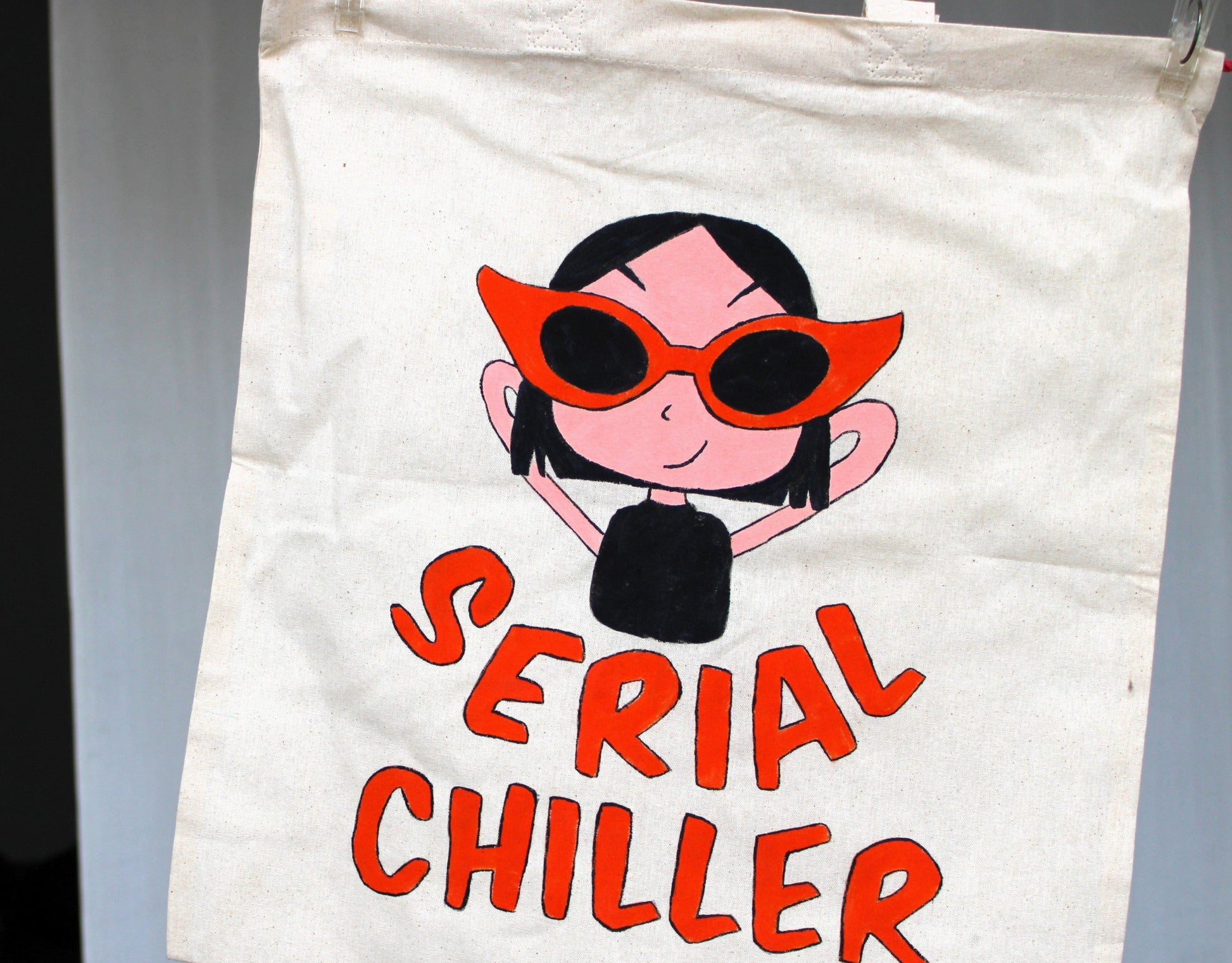 Close-up of the hand-painted "Serial Chiller" design on the tote bag, highlighting the character details and the bold lettering.