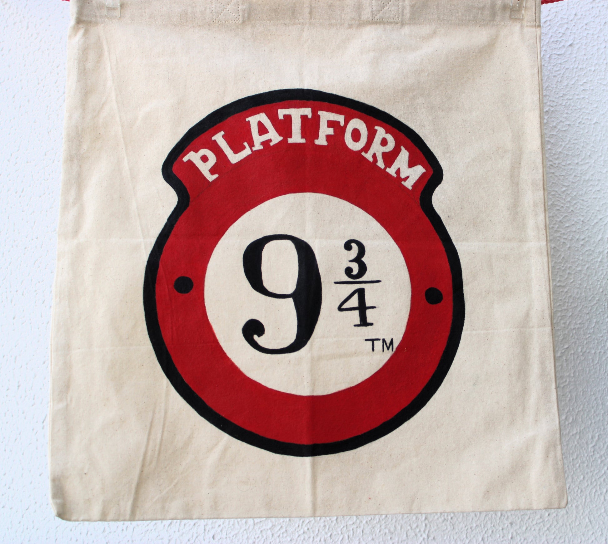 Close-up of the hand-painted Platform 9 3/4 logo on the Harry Potter tote bag, highlighting the intricate details of the numbers and text.