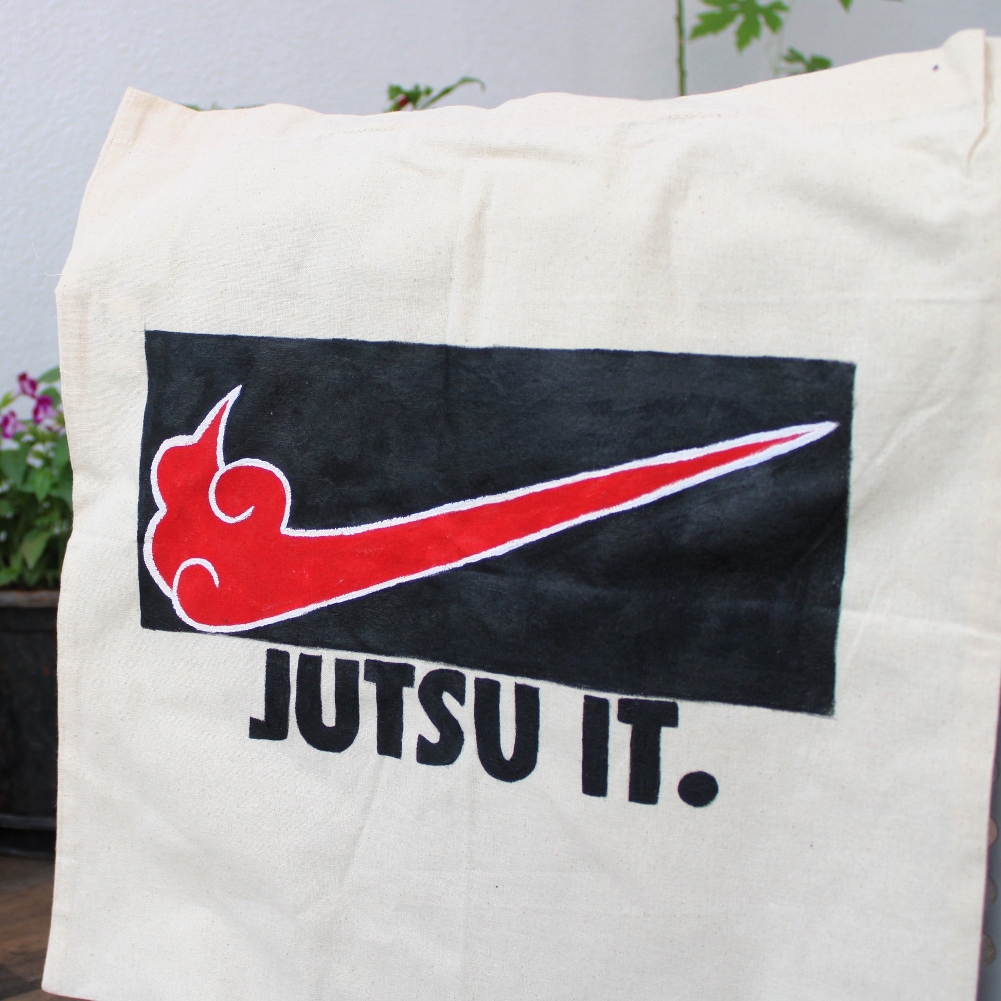 Hand-painted "Jutsu It" anime tote bag, highlighting the Akatsuki cloud detail and the custom lettering on the canvas.