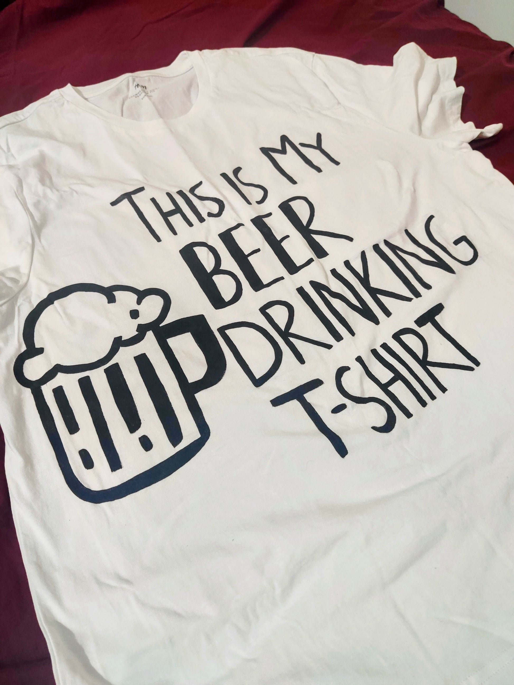 Close-up of the hand-painted text and beer mug design on a funny beer t shirt, showing the unique artwork details.